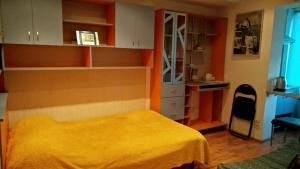 ブカレストにあるStudio French Embassyのベッドルーム(黄色いベッド1台付)、キッチンが備わります。