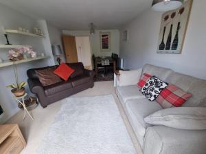 a living room with two couches and a table at Sky Night Serviced Apartments in Cardiff
