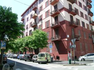 a red building with cars parked on the side of a street at lamarmora9 in La Spezia