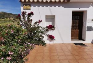 ein weißes Haus mit Blumen davor in der Unterkunft Apartamento Tramuntana in Perelló