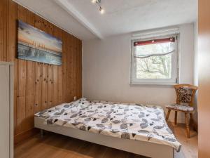 ein Schlafzimmer mit einem Bett, einem Stuhl und einem Fenster in der Unterkunft Cosy flat in Niepars with garden in Niepars