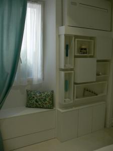 a white room with a window and a bench at Stone studio in Saint-Tropez