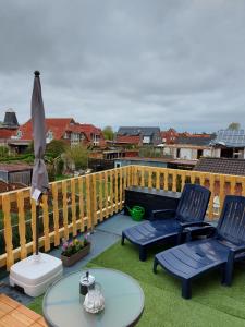 a patio with two chairs and a table and an umbrella at Ferienwohnung/Norden/4Personen in Norden