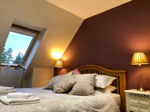 a bedroom with a bed with two lamps and a window at Hunters Lodge Apartments in Ballachulish