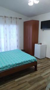 a bedroom with a bed and a cabinet and a television at Vržina Farm House Skadar Lake in Virpazar