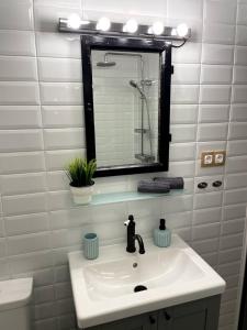 a white bathroom with a sink and a mirror at Zegzug Noszvaj in Noszvaj