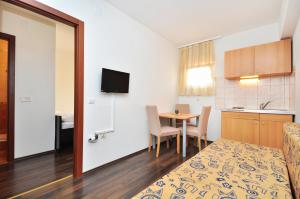 a small room with a kitchen and a table with chairs at Apartment House Jerko in Kaštela