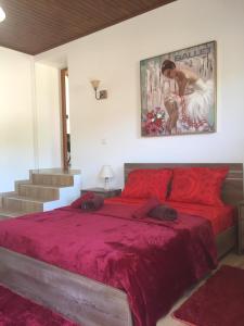 a bedroom with a red bed with a painting on the wall at Love Holiday Suite 1 in Tris Elies