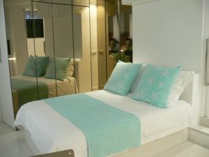una camera da letto con un letto con cuscini blu e bianchi di Stone studio a Saint-Tropez