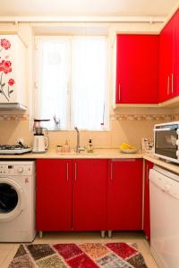 a kitchen with red cabinets and a washing machine at Best location in İstanbul in Istanbul
