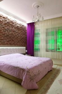 um quarto com uma cama rosa e uma parede de tijolos em Best location in İstanbul em Istambul