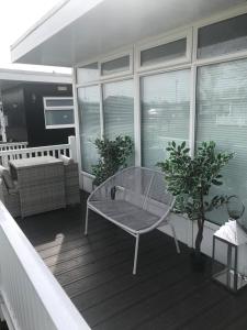 a balcony with a table and a couch on a porch at 49 Cherry Park Chalet in Chapel Saint Leonards