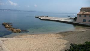 a beach with a building and the water at Stone studio in Saint-Tropez
