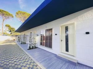 Casa blanca con techo azul y porche en Holiday Cabins Vlore en Vlorë