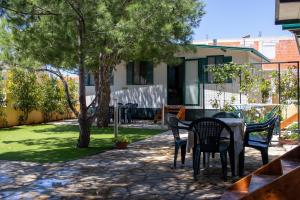 a patio with a table and chairs in a yard at Mobile homes Bonaca in Srima