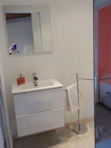 uma casa de banho branca com um lavatório e um espelho em Villa Angelina Garden em Grimaud