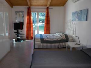 een slaapkamer met een bed en een tv. bij Villa Angelina Garden in Grimaud