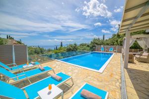 a swimming pool with lounge chairs and a swimming pool at Villa Hera-The infinity blue in Nisaki