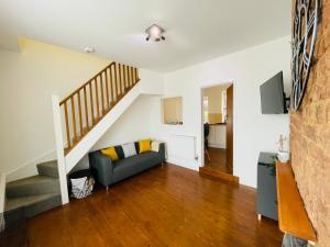 a living room with a couch and stairs at New North House by Staytor Accommodation in Exeter