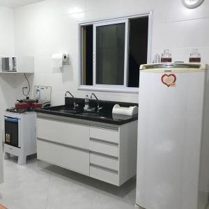 a kitchen with a refrigerator with a heart on it at Refugio Villa Verona Praia do Forte in Mata de Sao Joao