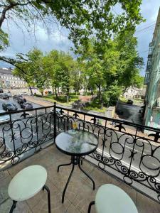 a table and chairs on a balcony with a view of a street at Amazing view of St. Michael’s square in Kyiv