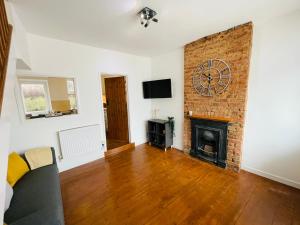 a living room with a fireplace and a tv at New North House by Staytor Accommodation in Exeter