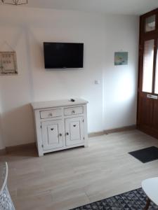 a room with a white cabinet and a tv on a wall at Maison de pêcheur idéalement située. in Le Tréport +2 photos