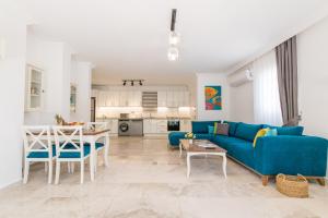 ein Wohnzimmer mit einem blauen Sofa und einem Tisch in der Unterkunft Garden Court Apartments in Kalkan