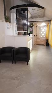 a lobby with two chairs and a counter and a kitchen at Albergo Paris in Sottomarina