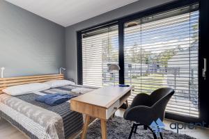 a bedroom with a bed and a desk and a desk chair at Dom FANØ Baltic 2 - Aprent in Pobierowo