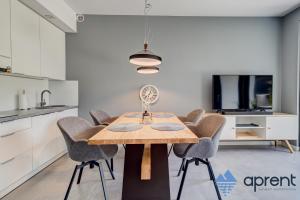 a kitchen and dining room with a wooden table and chairs at Dom FANØ Baltic 2 - Aprent in Pobierowo