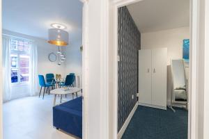 倫敦的住宿－Stunning 2 Bedrooms Apartment Next Door To Selfridges and Oxford Street，一间带桌子和蓝色椅子的用餐室