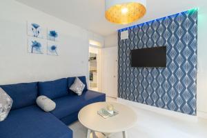 Stunning 2 Bedrooms Apartment Next Door To Selfridges and Oxford Street في لندن: غرفة معيشة مع أريكة زرقاء وطاولة
