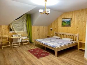 a bedroom with a bed and a table and chairs at Карпатський Замок in Rozluch +104 photos