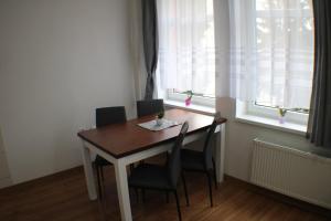 een tafel en stoelen in een kamer met een raam bij Apartmán KUBO in Liptovský Mikuláš