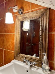 a bathroom with a sink and a mirror at Purola Farm Guesthouse in Saarijärvi
