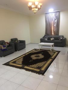 a living room with two couches and a rug at Al Basam Furnished Units in Yanbu