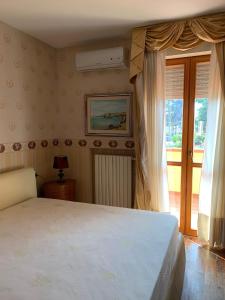 濱海弗蘭卡維拉的住宿－il Giardino di Sirius，卧室配有白色的床和窗户。