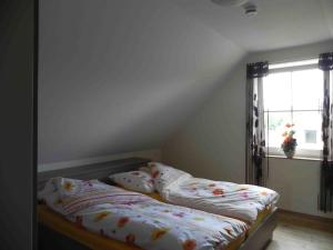 Schlafzimmer mit einem Bett und einem Fenster in der Unterkunft Ferienwohnungen am Unstrutwehr in Freyburg