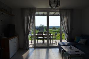 a living room with a couch and a sliding glass door at Domki na Wzgórzu - Rospuda in Filipów