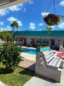 una piscina con un banco y un edificio en Georges Royal Inn, en Frederiksted