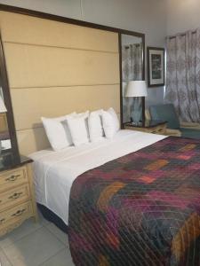 a hotel room with a large bed and a chair at Georges Royal Inn in Frederiksted