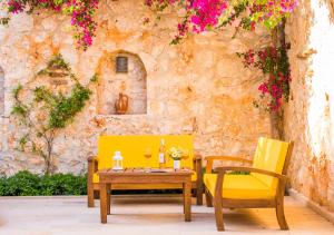 einen Tisch und zwei Stühle mit Weingläsern und Blumen in der Unterkunft Garden Court Apartments in Kalkan