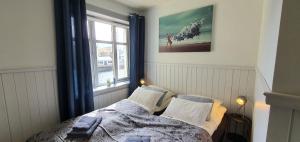Schlafzimmer mit einem Bett und einem Fenster in der Unterkunft Nyksund Ekspedisjonen in Nyksund