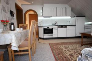 a kitchen with a table and a kitchen with white cabinets at Ferienhaus Marienweg in Hallenberg
