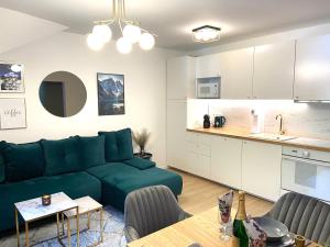 a living room with a green couch and a kitchen at Apartmán Klára in Terchová