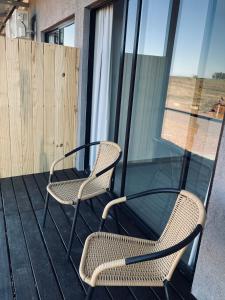 2 Stühle und ein Glastisch auf dem Balkon in der Unterkunft PLC Hotel Centenario in Paso de los Toros