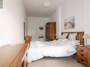 a bedroom with two beds and a wooden desk at Gull Cottage in Tintagel
