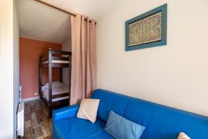 een woonkamer met een blauwe bank en een stapelbed bij T2 parking nice view in Lourdes