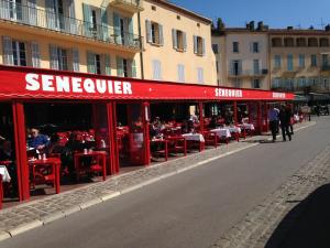 a restaurant with red tables and chairs on a street at Stone studio in Saint-Tropez